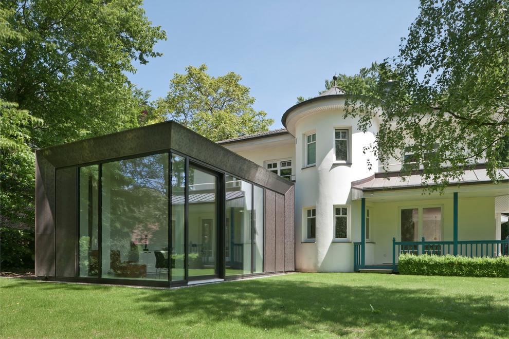 Foto della facciata di una casa piccola bianca contemporanea a due piani con rivestimento in metallo e tetto piano
