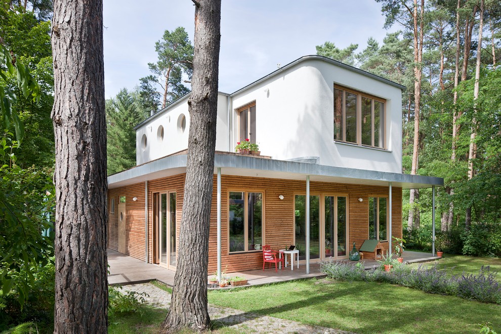 Esempio della facciata di una casa scandinava con rivestimento in legno e tetto piano