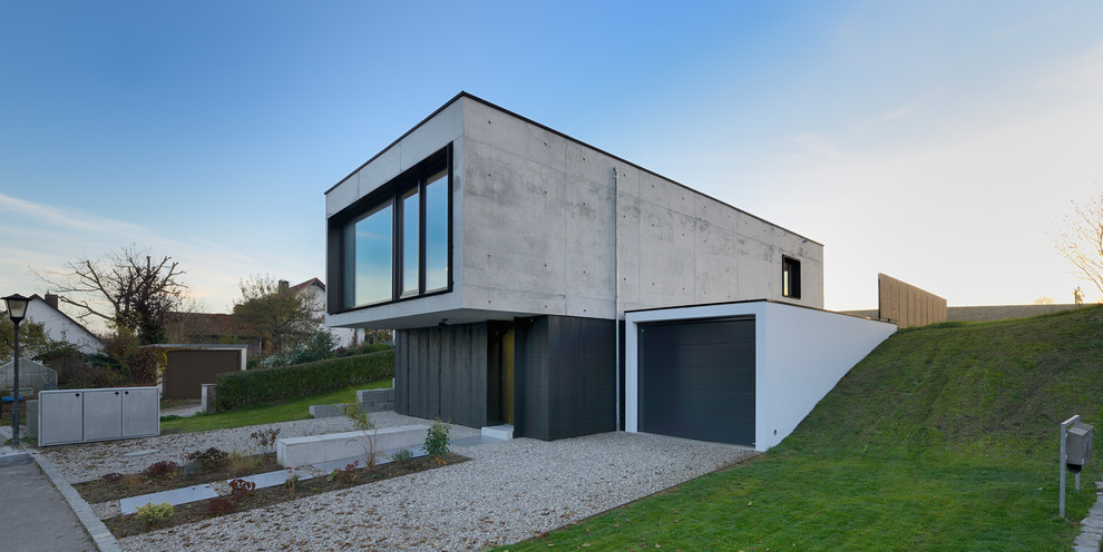 Diseño de fachada negra contemporánea pequeña de dos plantas con revestimiento de hormigón
