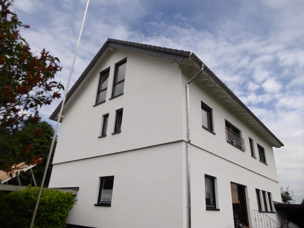 Klassisches Einfamilienhaus mit Putzfassade, weißer Fassadenfarbe, Satteldach und Ziegeldach in Sonstige
