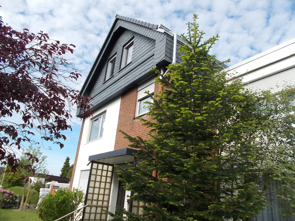 Mittelgroßes, Dreistöckiges Klassisches Reihenhaus mit Mix-Fassade, grauer Fassadenfarbe und Ziegeldach in Sonstige