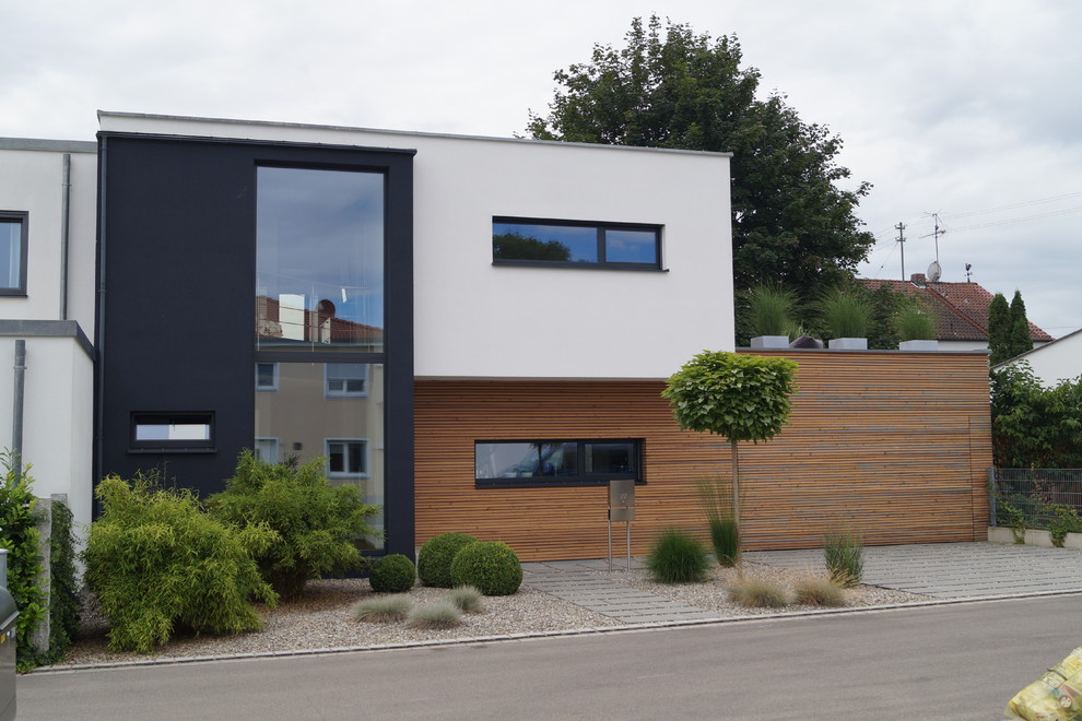 Cette photo montre une façade de maison noire tendance de taille moyenne et à un étage avec un revêtement mixte et un toit plat.