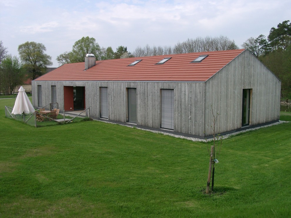 Immagine della facciata di una casa grigia contemporanea a un piano di medie dimensioni con rivestimento in legno e tetto a capanna