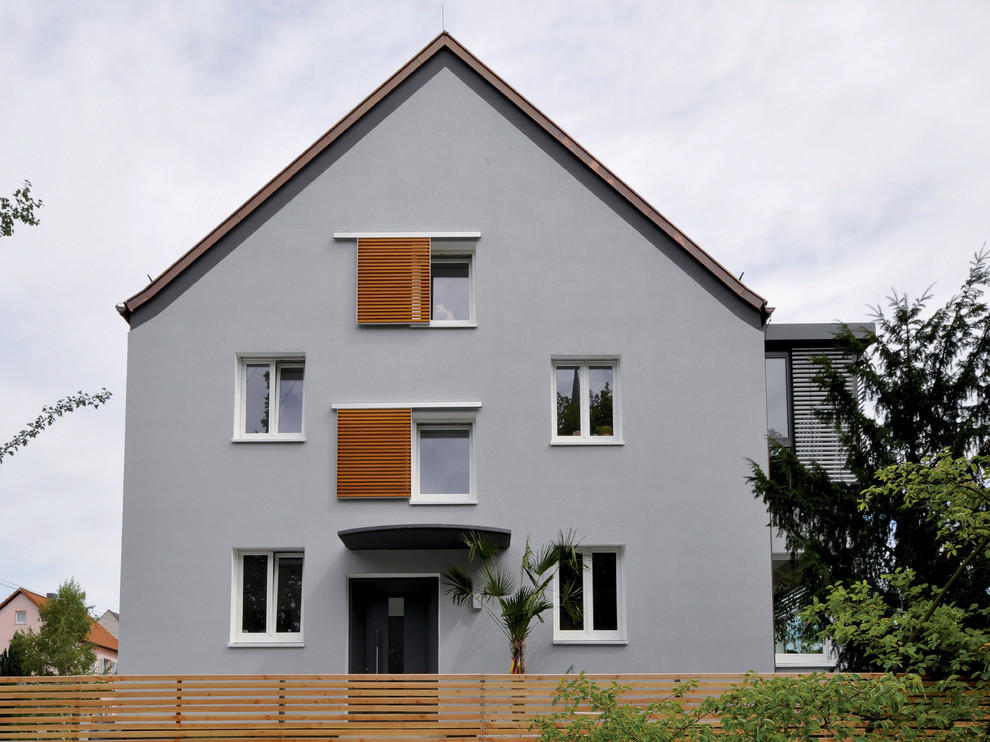 Réalisation d'une façade de maison grise design à deux étages et plus et de taille moyenne avec un toit à deux pans.
