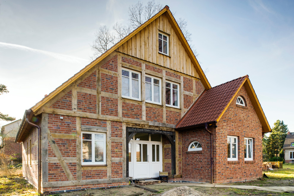 Diseño de fachada roja de estilo de casa de campo grande de tres plantas con tejado a dos aguas