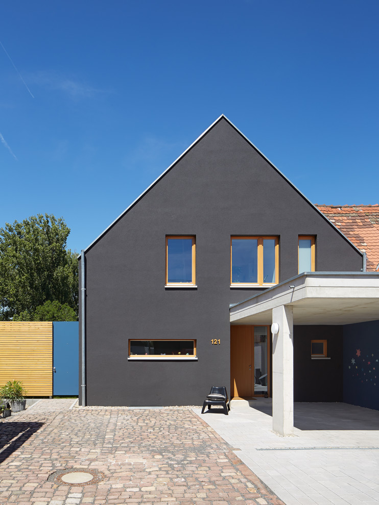 На фото: двухэтажный, черный дом среднего размера в современном стиле с двускатной крышей