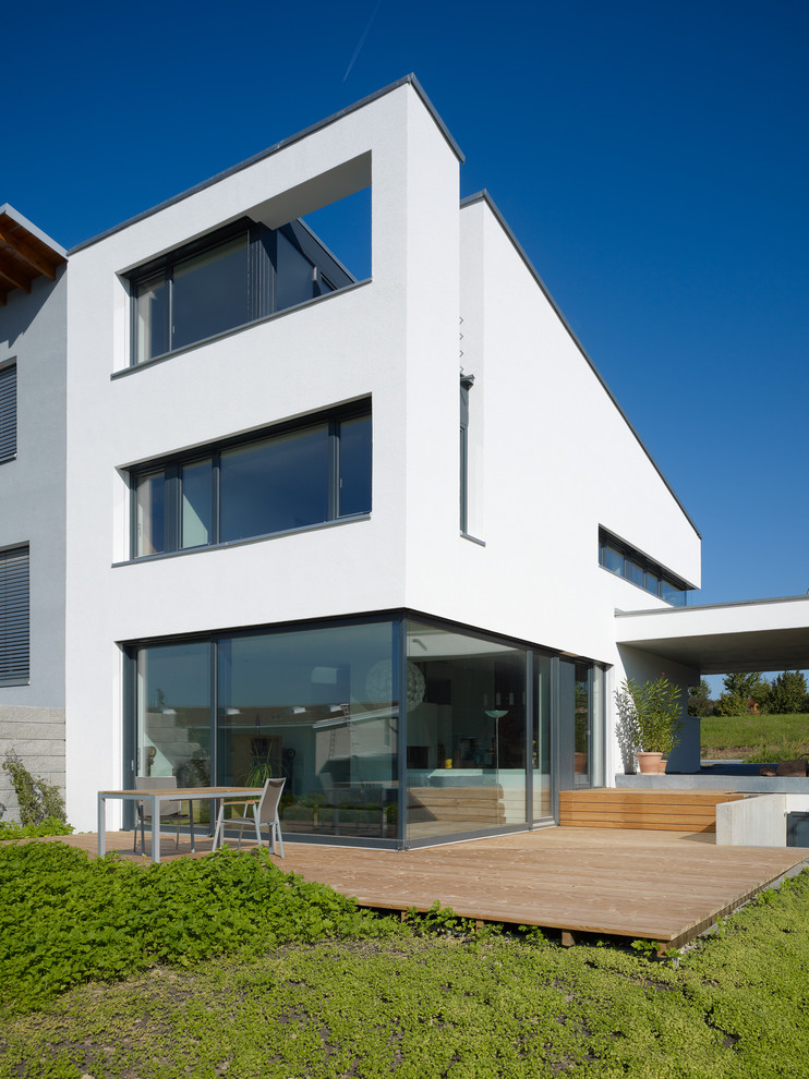 Mittelgroßes, Dreistöckiges Modernes Haus mit weißer Fassadenfarbe und Pultdach in Berlin