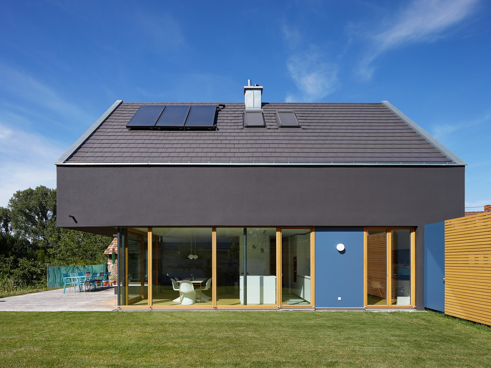 Blue and medium sized contemporary two floor house exterior in Berlin with a pitched roof.