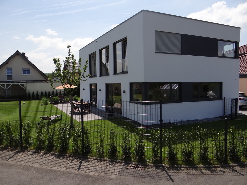 Mittelgroßes, Zweistöckiges Modernes Haus mit Putzfassade, weißer Fassadenfarbe und Flachdach in Bonn