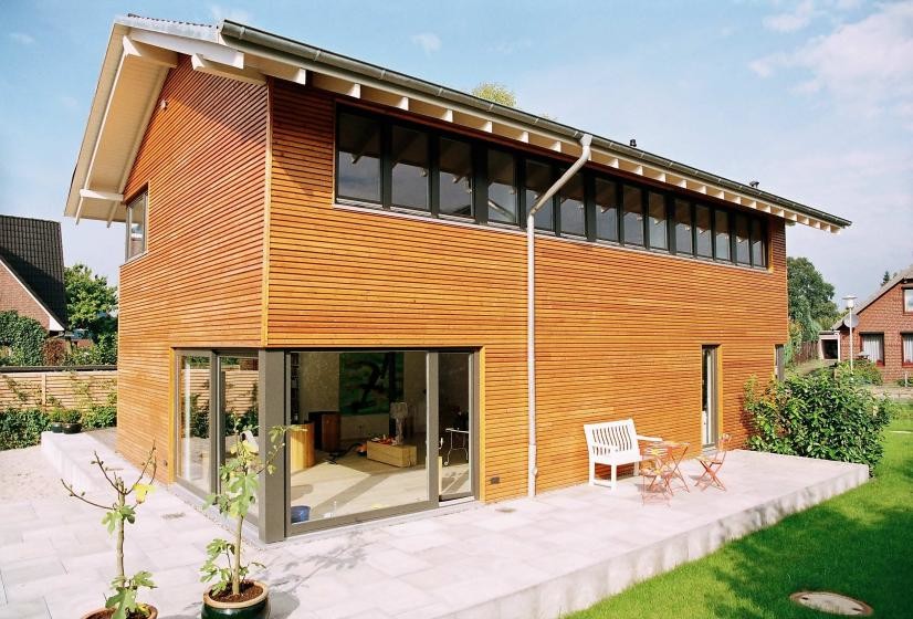 Inspiration for an expansive and brown contemporary two floor house exterior in Hamburg with wood cladding and a pitched roof.