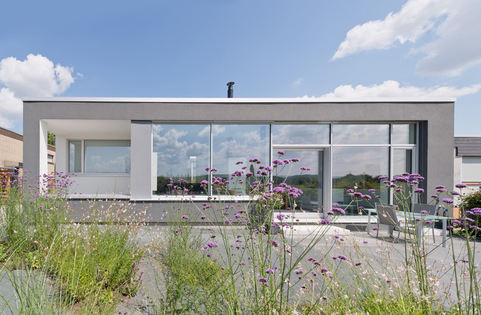 Mittelgroßes, Einstöckiges Modernes Haus mit grauer Fassadenfarbe, Flachdach und Mix-Fassade in Hannover