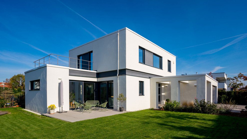 Inspiration for a medium sized and white contemporary two floor render detached house in Other with a flat roof.