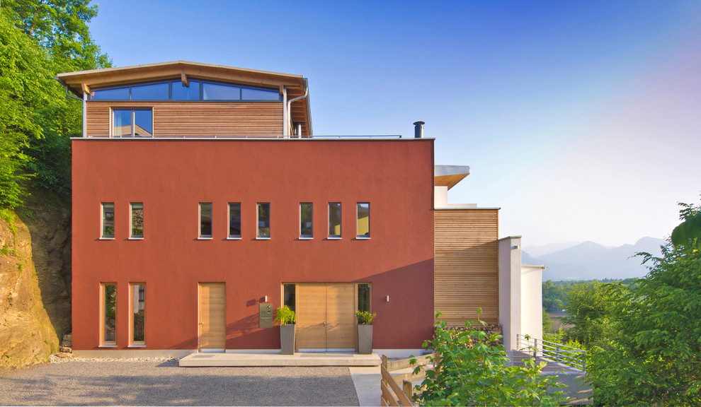 Großes, Dreistöckiges Modernes Einfamilienhaus mit Putzfassade, roter Fassadenfarbe und Satteldach in Sonstige