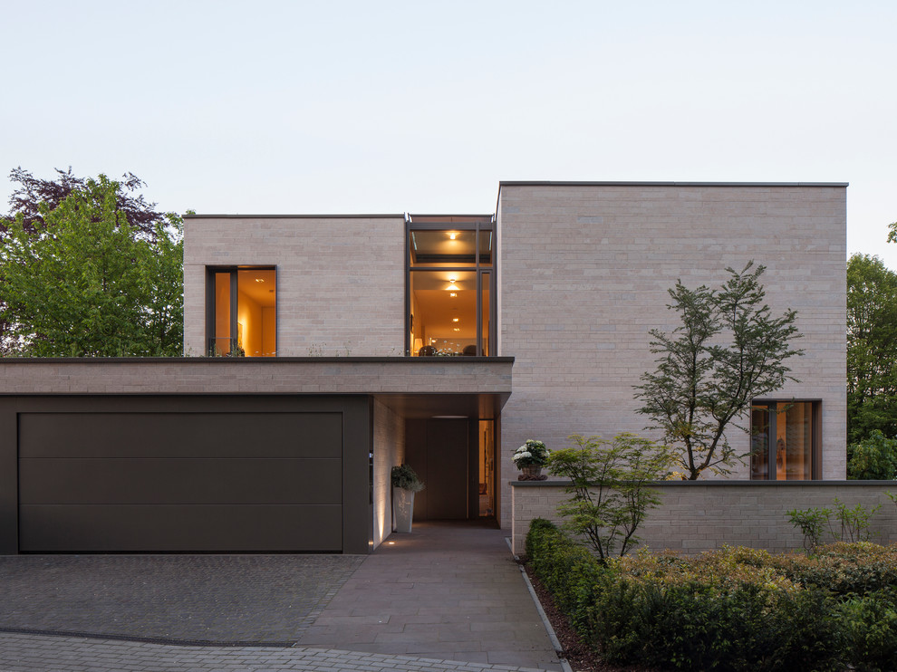 Стильный дизайн: двухэтажный, бежевый дом среднего размера в современном стиле с плоской крышей - последний тренд
