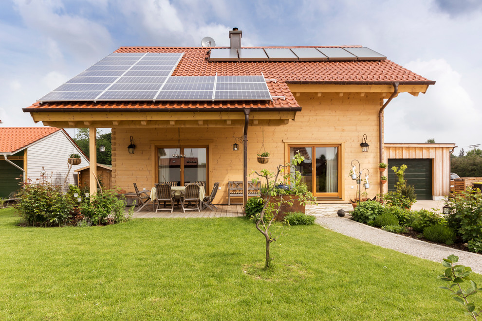 Kleine, Zweistöckige Landhausstil Holzfassade Haus mit brauner Fassadenfarbe und Satteldach in Leipzig