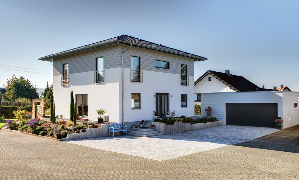 Идея дизайна: двухэтажный частный загородный дом в средиземноморском стиле с облицовкой из цементной штукатурки, полувальмовой крышей и черепичной крышей
