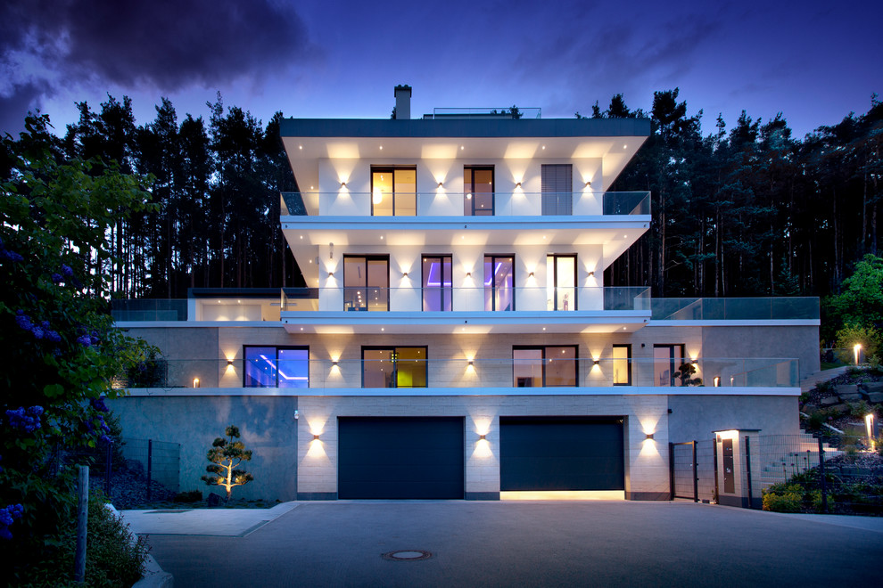 Photo of an expansive and beige contemporary detached house in Nuremberg with three floors and a flat roof.