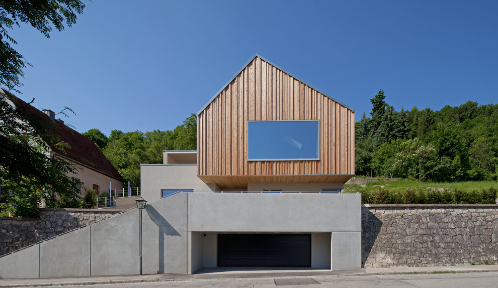 Mittelgroßes, Zweistöckiges Modernes Haus mit Mix-Fassade, Satteldach und grauer Fassadenfarbe in München