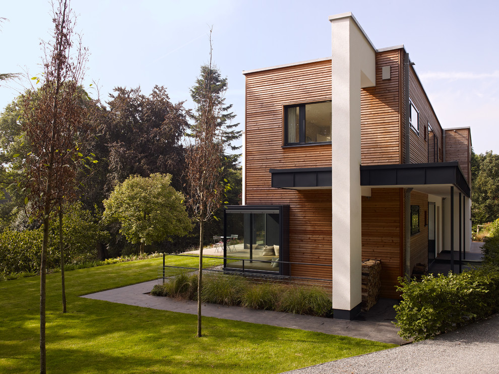 Пример оригинального дизайна: большой, двухэтажный, деревянный, коричневый дом в современном стиле с плоской крышей