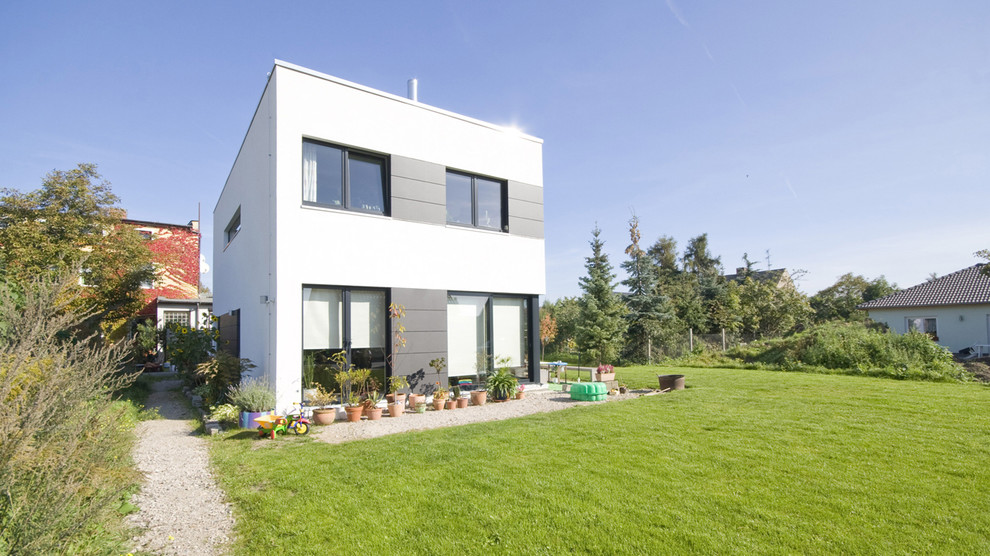 Ejemplo de fachada blanca moderna de tamaño medio de dos plantas con tejado plano y revestimiento de hormigón