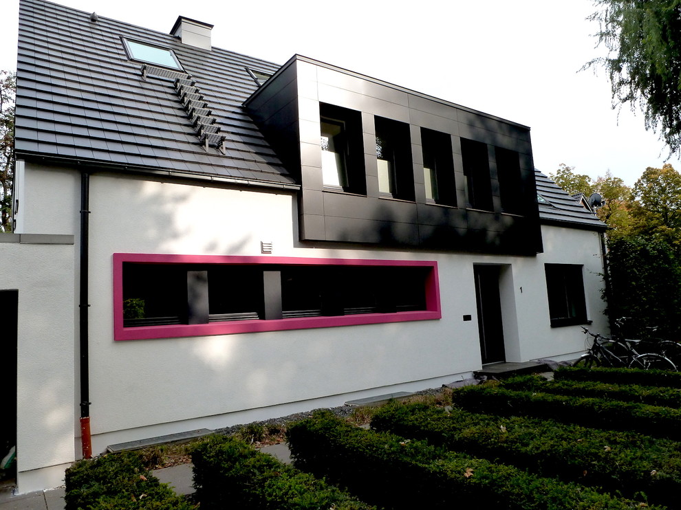 Modernes Einfamilienhaus mit Putzfassade, weißer Fassadenfarbe, Satteldach und Ziegeldach in Düsseldorf