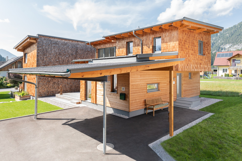 Idées déco pour une très grande façade de maison marron contemporaine en bois à un étage avec un toit à deux pans et un toit en shingle.