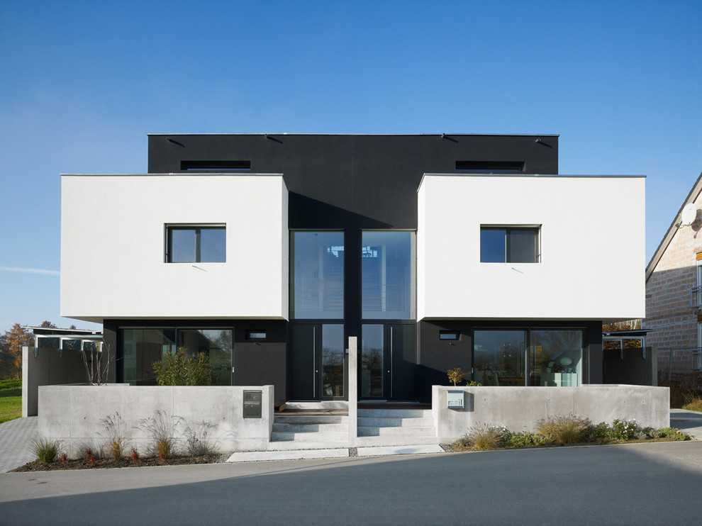 На фото: большой, трехэтажный, черный дом в стиле модернизм с комбинированной облицовкой и плоской крышей с