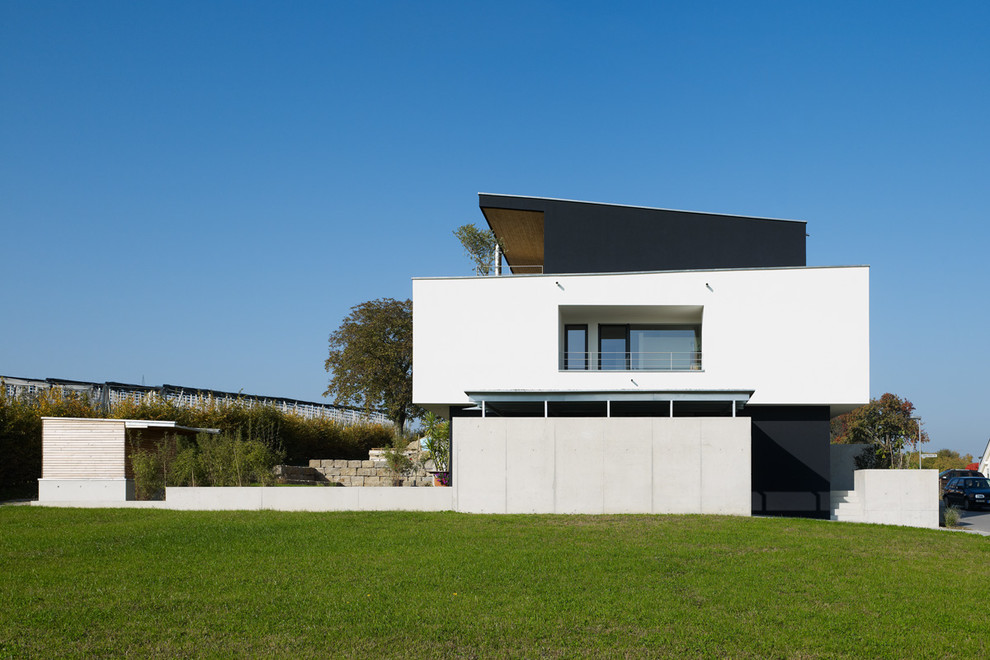 Großes, Dreistöckiges Modernes Haus mit Faserzement-Fassade, weißer Fassadenfarbe und Pultdach in Sonstige