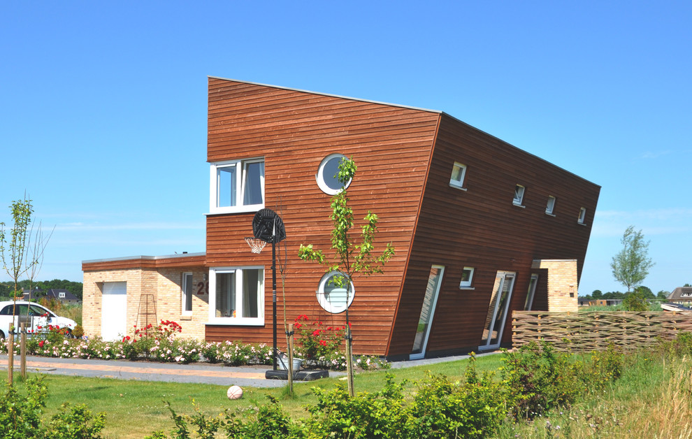 Mittelgroßes, Zweistöckiges Modernes Haus mit Mix-Fassade, brauner Fassadenfarbe und Pultdach in Sonstige