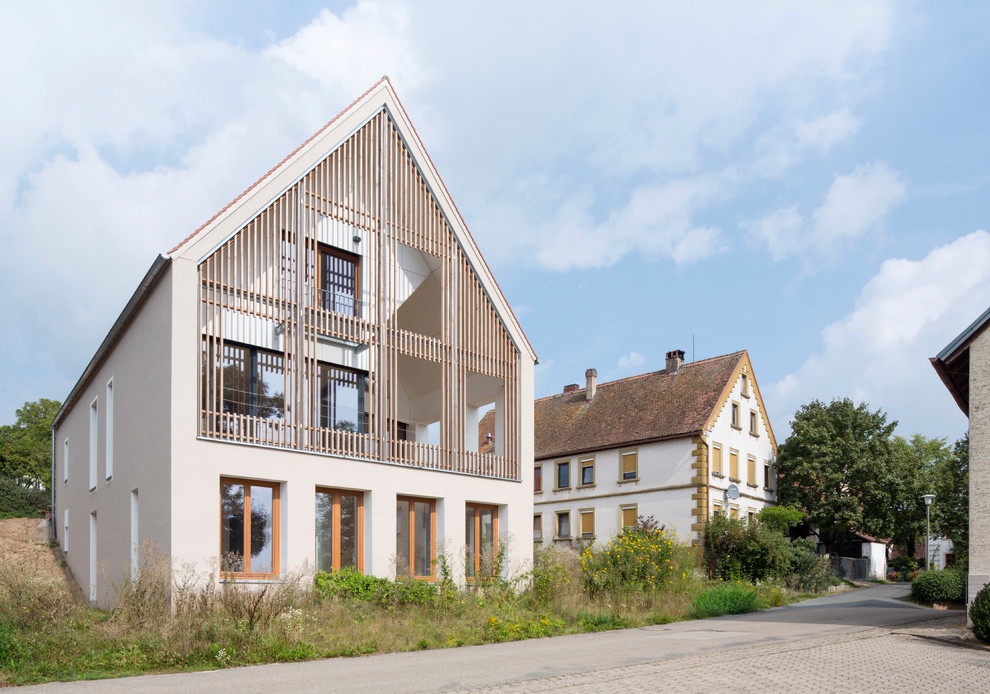 Inspiration for a large and multi-coloured contemporary detached house in Nuremberg with three floors, mixed cladding, a pitched roof and a shingle roof.