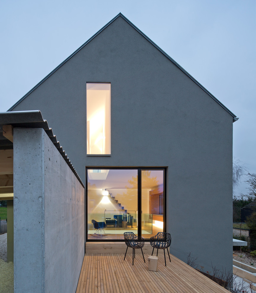 Идея дизайна: двухэтажный, серый дуплекс среднего размера в современном стиле с облицовкой из цементной штукатурки и двускатной крышей
