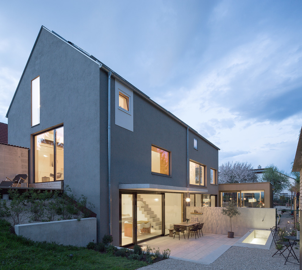 Источник вдохновения для домашнего уюта: двухэтажный, серый дуплекс среднего размера в современном стиле с облицовкой из цементной штукатурки и двускатной крышей