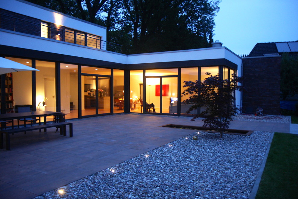 Inspiration pour une façade de maison blanche design de taille moyenne et de plain-pied avec un revêtement mixte, un toit plat et un toit végétal.