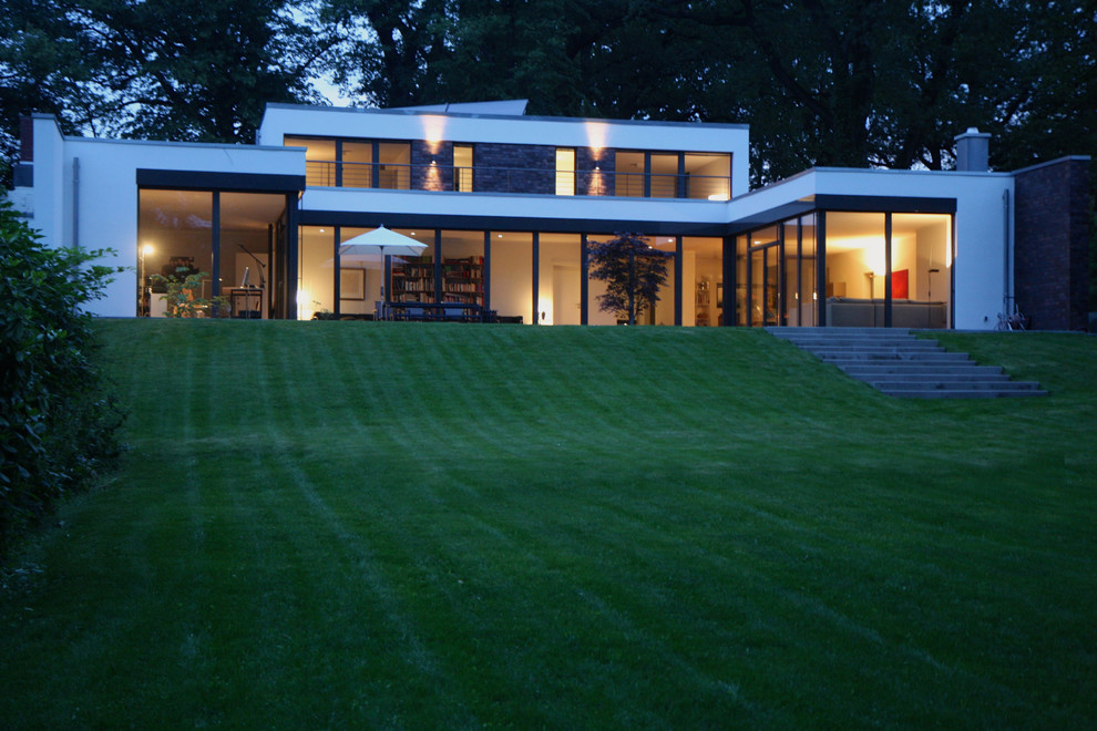 Inspiration för ett mellanstort funkis vitt hus, med allt i ett plan, blandad fasad, platt tak och levande tak