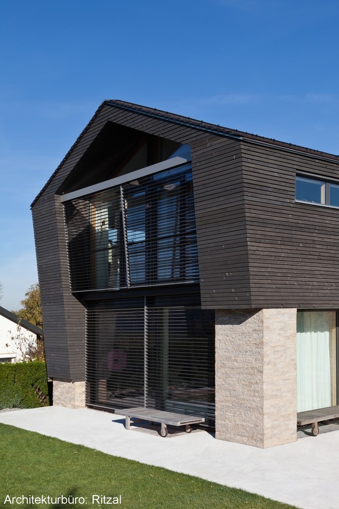 Inspiration pour une façade de maison grise design en bois.