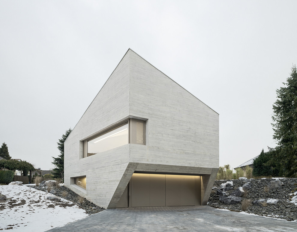 Diseño de fachada de casa gris minimalista de tamaño medio de dos plantas con revestimiento de hormigón