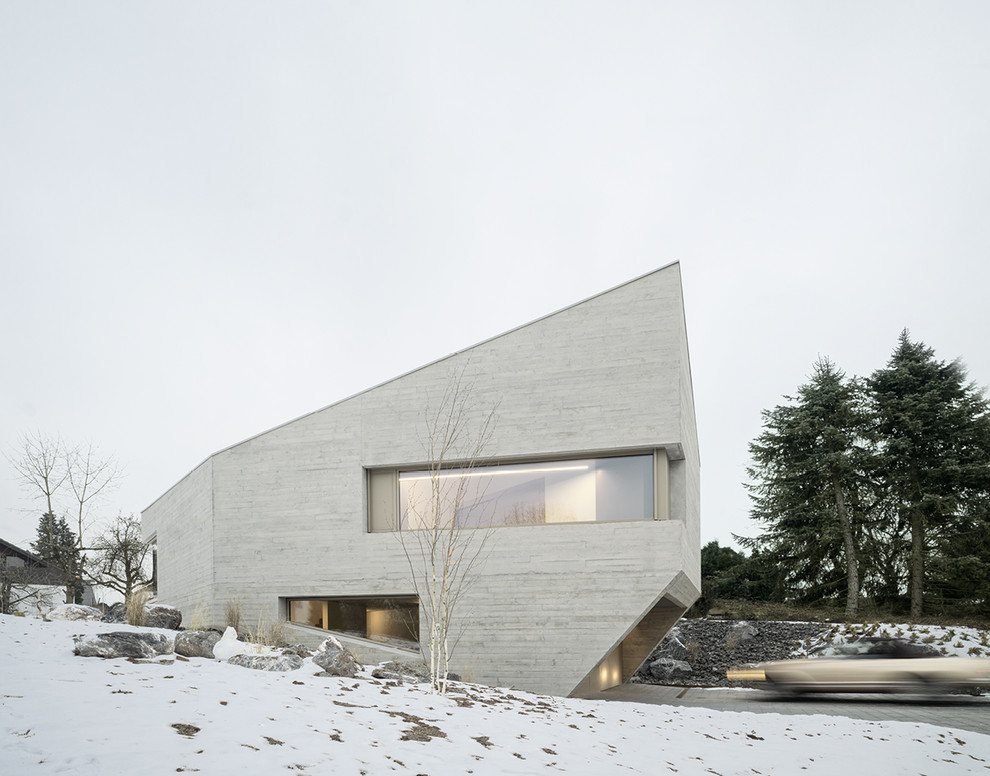 Mittelgroßes, Zweistöckiges Modernes Einfamilienhaus mit Betonfassade, grauer Fassadenfarbe und Pultdach in Stuttgart