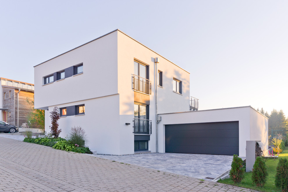 Mittelgroßes, Zweistöckiges Modernes Haus mit Putzfassade, weißer Fassadenfarbe und Flachdach in Nürnberg