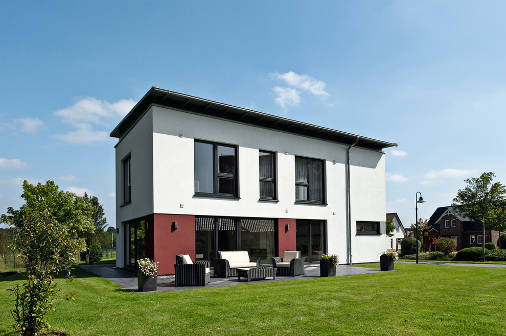 Mittelgroßes, Zweistöckiges Modernes Einfamilienhaus mit Putzfassade, weißer Fassadenfarbe, Flachdach und Ziegeldach in Sonstige