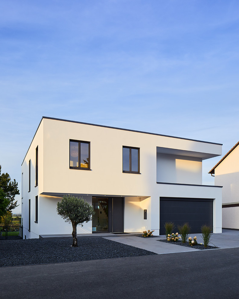 Exemple d'une façade de maison blanche tendance en stuc de taille moyenne et à un étage avec un toit plat.
