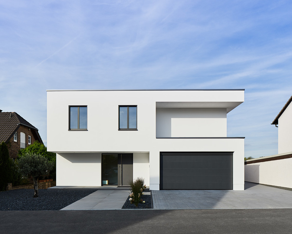 Идея дизайна: двухэтажный, белый частный загородный дом среднего размера в современном стиле с облицовкой из цементной штукатурки и плоской крышей