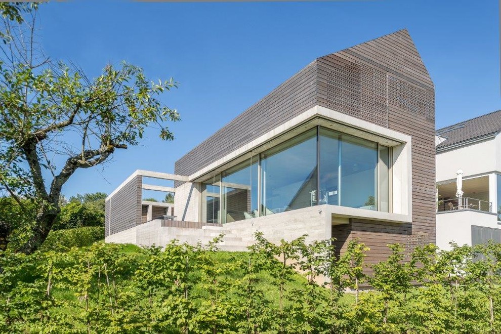 Zweistöckige, Mittelgroße Moderne Holzfassade Haus mit brauner Fassadenfarbe und Satteldach in Hannover