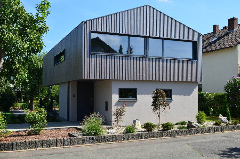 Idées déco pour une façade de maison grise contemporaine en bois à un étage et de taille moyenne avec un toit à deux pans.