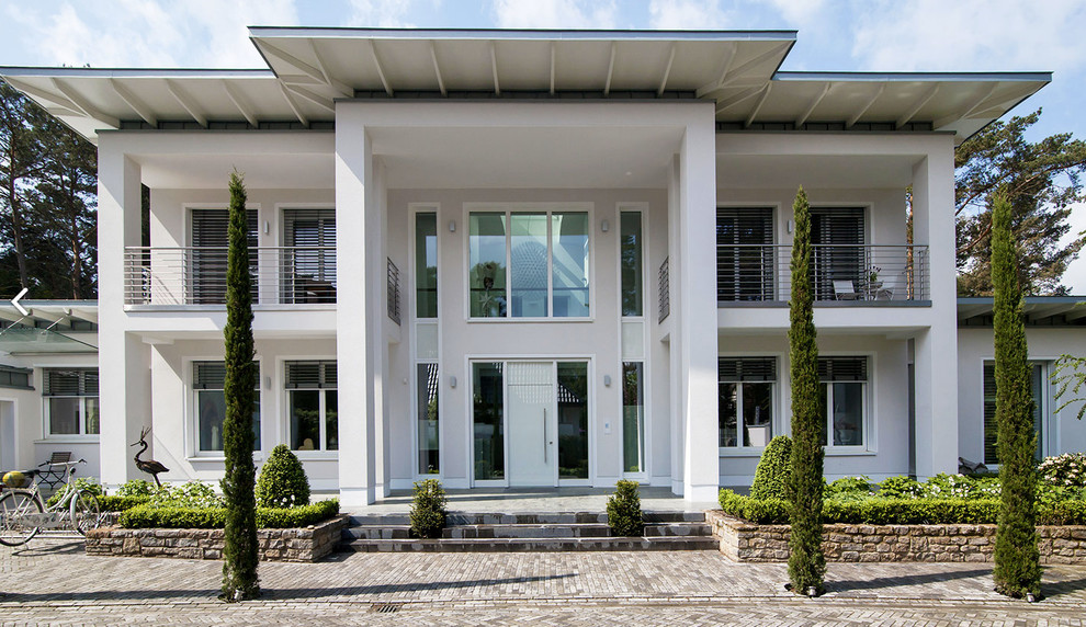 Diseño de fachada beige actual grande de dos plantas con revestimiento de estuco y tejado plano