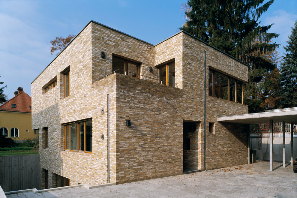 Idée de décoration pour une façade de maison design en brique de taille moyenne et à deux étages et plus avec un toit plat.