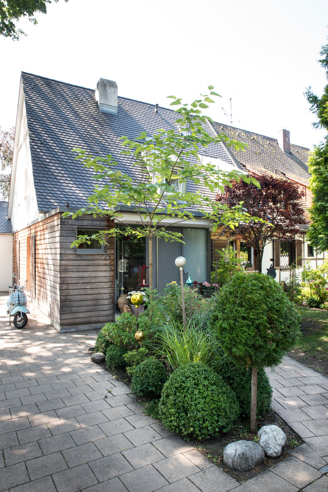 Ejemplo de fachada de casa bifamiliar romántica de tamaño medio de dos plantas con revestimientos combinados y tejado a dos aguas