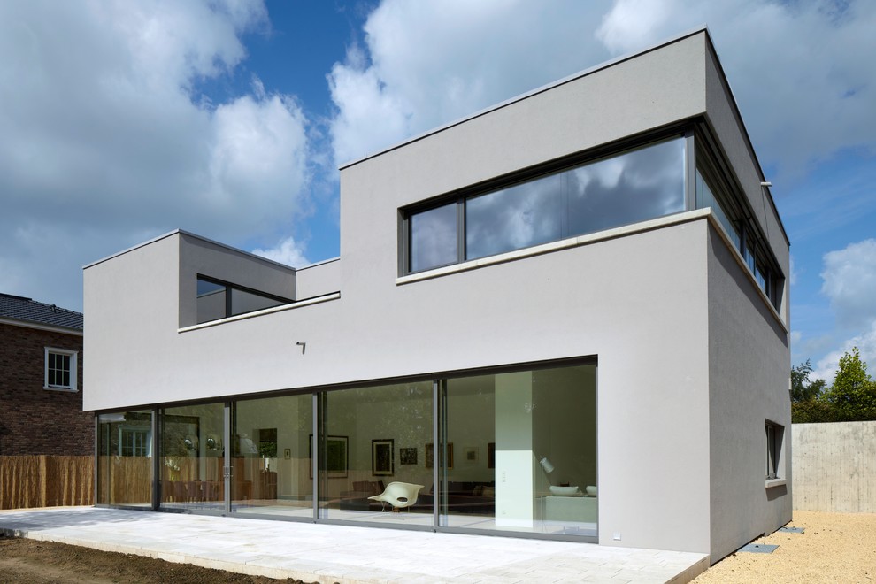 Large and gey contemporary two floor render house exterior in Dusseldorf with a flat roof.