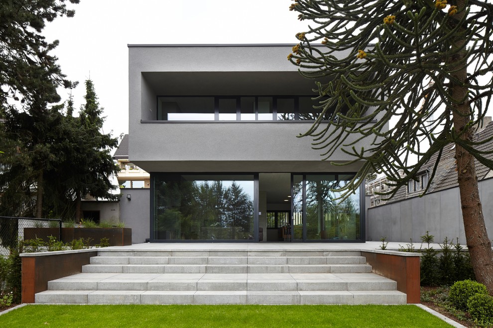Inspiration for a medium sized and gey contemporary two floor render house exterior in Dusseldorf with a flat roof.