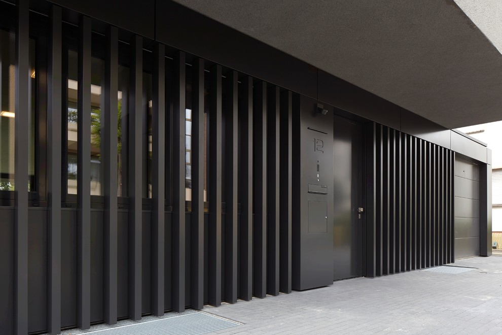 Idee per la facciata di una casa grigia contemporanea a due piani di medie dimensioni con rivestimento in metallo e tetto piano