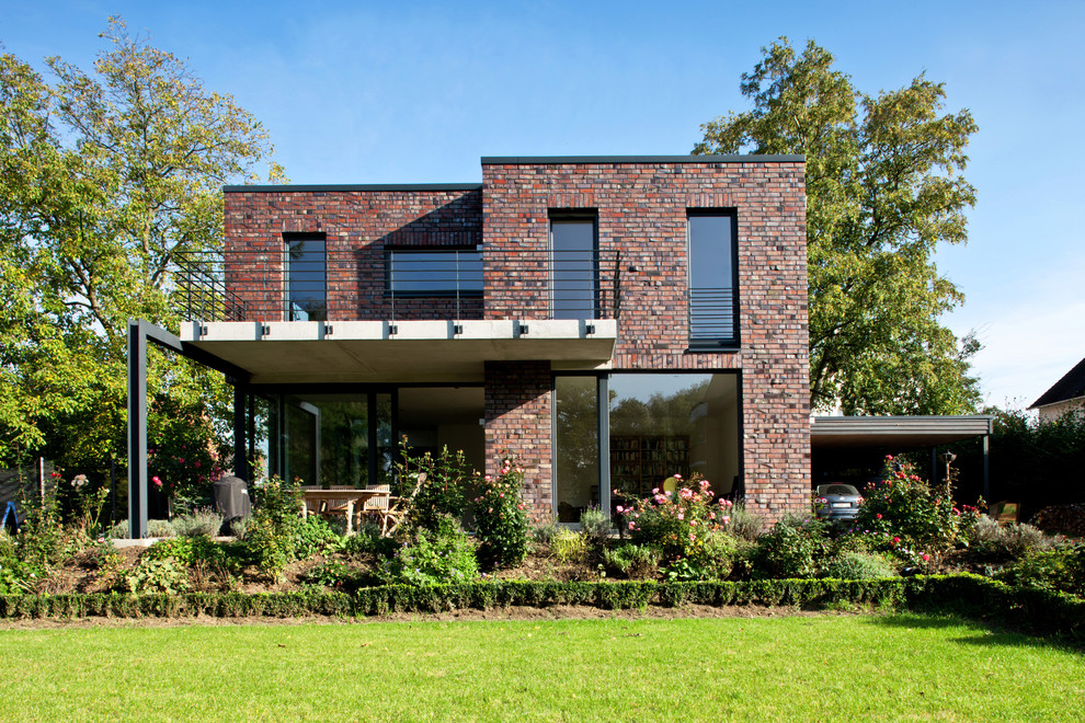 На фото: большой, кирпичный, коричневый, двухэтажный дом в современном стиле с плоской крышей